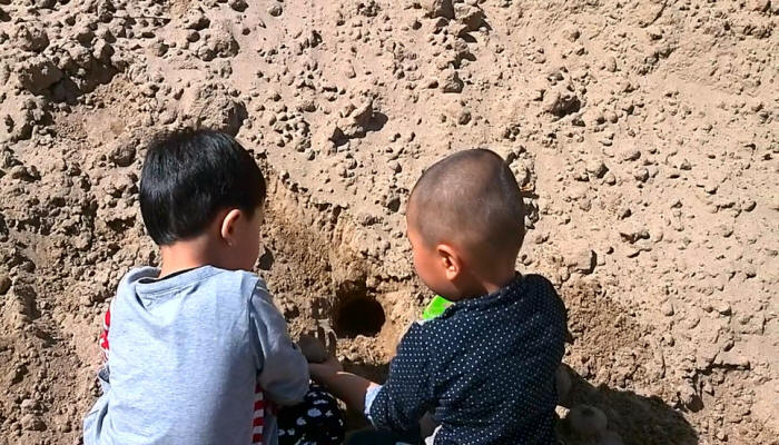 课外活动中的中国传统文化教育培训中心小朋友在沙堆上挖洞